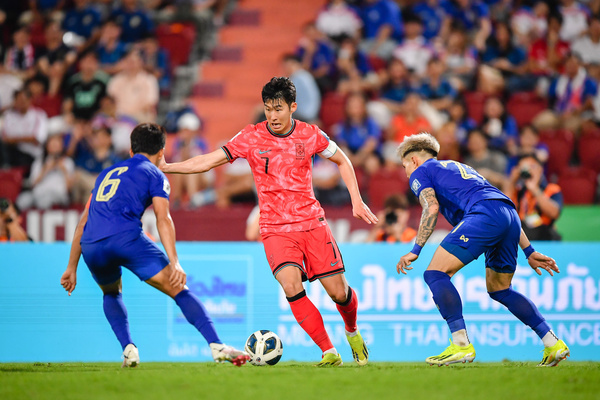 Son Heung-Min (C) of South Korea and Sarach Yooyen (L) and Suphanan Bureerat (R) of Thailand seen in action during the Asian World Cup qualifying round, second round, Group C match between Thailand and South Korea at Rajamangala Stadium. (Final score; Thailand 0:3 South Korea)