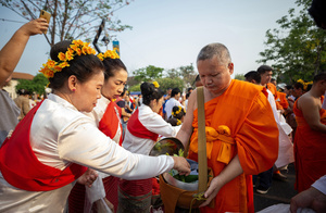 A Thai Woman wearing traditional costumes donates to the Buddhist monks during the 728th anniversary celebrations of Chiang Mai city. The city of Chiang Mai was founded by The three kings: King Mangrai, King Ngam Mueang and King Ram Khamhaeng on 12 April 1296.