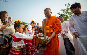 A kid wearing traditional costumes offers food to the Buddhist monks during the 728th anniversary celebrations of Chiang Mai city. The city of Chiang Mai was founded by The three kings: King Mangrai, King Ngam Mueang and King Ram Khamhaeng on 12 April 1296.
