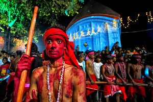 A Hindu devotee with his red colored face poses for a photo during the annual Gajan Festival. Gajan is a Hindu festival celebrated mostly in the rural part of West Bengal. The festival is related to Lord Shiva and as per Mythology on the last day of Bengali Calendar (Middle of April) devotees used to worship dead bodies to satisfy Lord Shiva for better rain and harvest. The central theme of this festival is deriving satisfaction through non-sexual pain, devotion and sacrifice.