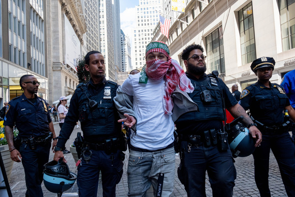 NYPD arrest a protester wearing a kefiyah and a green Hamas band on his head during the rally. Pro-Palestinian activist group Within Our lifetime staged a protest at 11 Wall Street. The protest later attempted to march across the Brooklyn Bridge as part of a multi-city/multi-country attempt to create an “economic blockade” in solidarity with Palestine. Several arrests were made.