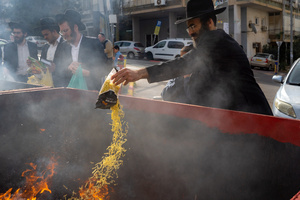 A Jewish man seen throwing leaven into the fire during the Biur Chametz. During the Biur Chametz, religious Jews fulfill their obligation to inspect their homes for any leaven and eliminate it before the night of Passover. In ultra-Orthodox cities in Israel, fires are set up in major locations in the city for this purpose, where people bring their bread leftovers to burn the leaven. During the seven days of Passover, they are prohibited from eating or possessing any leaven, symbolizing the dough the Israelites did not have time to allow to rise before the Exodus from Egypt. Biur Chametz, also known as 'the burning of the leavened goods,' is a Jewish ceremonial ritual involving the burning of leavened foods (chamets) to mark the start of Passover.
