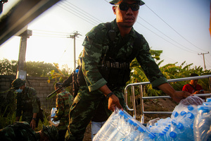 A Thai soldier seen carrying water bottles as relief aid for the war victims who fled to Mae Sot. On April 12, Karen KNLA and PDF forces raided the army's 275th military garrison in Myawady town, prompting more than 100 soldiers to attempt to flee to Thailand across Friendship Bridge No. 2. The KNLA/PDF joint forces subsequently attacked these soldiers on the night of April 19th. According to residents, the military council's air response included no fewer than 40 bombs being dropped. As a result of the fighting, approximately 2,000 people fled to Mae Sot, Thailand, across the Moei (Thaung Yin) River.