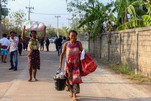 People carry their bags as they arrive in Mae Sot after fleeing from the Myawaddy war. On April 12, Karen KNLA and PDF forces raided the army's 275th military garrison in Myawady town, prompting more than 100 soldiers to attempt to flee to Thailand across Friendship Bridge No. 2. The KNLA/PDF joint forces subsequently attacked these soldiers on the night of April 19th. According to residents, the military council's air response included no fewer than 40 bombs being dropped. As a result of the fighting, approximately 2,000 people fled to Mae Sot, Thailand, across the Moei (Thaung Yin) River.