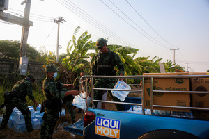 A Thai soldier seen carrying water bottles as relief aid for the war victims who fled to Mae Sot. On April 12, Karen KNLA and PDF forces raided the army's 275th military garrison in Myawady town, prompting more than 100 soldiers to attempt to flee to Thailand across Friendship Bridge No. 2. The KNLA/PDF joint forces subsequently attacked these soldiers on the night of April 19th. According to residents, the military council's air response included no fewer than 40 bombs being dropped. As a result of the fighting, approximately 2,000 people fled to Mae Sot, Thailand, across the Moei (Thaung Yin) River.