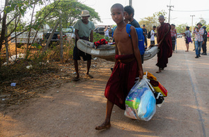 Men and a novice monk are seen carrying a sick elderly man as they flee from the Myawaddy War to Mae Sot. On April 12, Karen KNLA and PDF forces raided the army's 275th military garrison in Myawady town, prompting more than 100 soldiers to attempt to flee to Thailand across Friendship Bridge No. 2. The KNLA/PDF joint forces subsequently attacked these soldiers on the night of April 19th. According to residents, the military council's air response included no fewer than 40 bombs being dropped. As a result of the fighting, approximately 2,000 people fled to Mae Sot, Thailand, across the Moei (Thaung Yin) River.