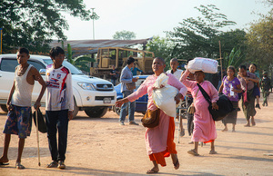 People carry their bags as they arrive in Mae Sot after fleeing from the Myawaddy war. On April 12, Karen KNLA and PDF forces raided the army's 275th military garrison in Myawady town, prompting more than 100 soldiers to attempt to flee to Thailand across Friendship Bridge No. 2. The KNLA/PDF joint forces subsequently attacked these soldiers on the night of April 19th. According to residents, the military council's air response included no fewer than 40 bombs being dropped. As a result of the fighting, approximately 2,000 people fled to Mae Sot, Thailand, across the Moei (Thaung Yin) River.