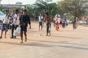 People carry their bags as they arrive in Mae Sot after fleeing from the Myawaddy war. On April 12, Karen KNLA and PDF forces raided the army's 275th military garrison in Myawady town, prompting more than 100 soldiers to attempt to flee to Thailand across Friendship Bridge No. 2. The KNLA/PDF joint forces subsequently attacked these soldiers on the night of April 19th. According to residents, the military council's air response included no fewer than 40 bombs being dropped. As a result of the fighting, approximately 2,000 people fled to Mae Sot, Thailand, across the Moei (Thaung Yin) River.