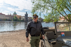 A history enthusiast dressed in World War II US Army uniform seen in front of famous Charles Bridge before the Convoy of Liberty event in Prague. The Convoy of Liberty commemorates the liberation of the western part of the Czech Republic from Nazi occupation by the US Army, as well as the 79th anniversary of the end of World War II in 1945. Throughout the convoy, individual military history clubs and army forces re-enactors join the routes of Allied armies.