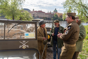 A history enthusiasts dressed in World War II US Army uniform seen in front of famous Charles Bridge before the Convoy of Liberty event in Prague. The Convoy of Liberty commemorates the liberation of the western part of the Czech Republic from Nazi occupation by the US Army, as well as the 79th anniversary of the end of World War II in 1945. Throughout the convoy, individual military history clubs and army forces re-enactors join the routes of Allied armies.
