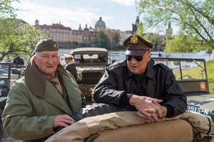 A history enthusiasts dressed in World War II US Army uniform seen in front of famous Charles Bridge before the Convoy of Liberty event in Prague. The Convoy of Liberty commemorates the liberation of the western part of the Czech Republic from Nazi occupation by the US Army, as well as the 79th anniversary of the end of World War II in 1945. Throughout the convoy, individual military history clubs and army forces re-enactors join the routes of Allied armies.