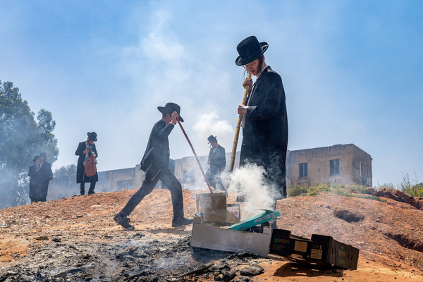 Young Jewish boys set up a fire during the Biur Chametz. During the Biur Chametz, religious Jews fulfill their obligation to inspect their homes for any leaven and remove it before the onset of Passover. In ultra-Orthodox cities in Israel, fires are set up in prominent locations for this purpose, where individuals bring their leftover bread to burn the leaven. Throughout the seven days of Passover, they abstain from eating or possessing any leaven, symbolizing the haste with which the Israelites fled Egypt and did not allow their dough to rise. Biur Chametz, also known as 'the burning of the leavened goods,' is a Jewish ceremonial ritual involving the burning of leavened foods (chamets) to commemorate the beginning of Passover.