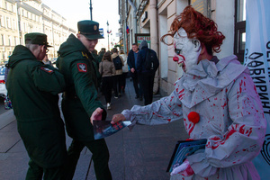 After the rehearsal for the May 9 Victory Parade on Palace Square, servicemen of the Russian Armed Forces take an advertising brochure from an animator dressed as a clown.