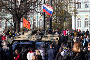 Spectators watch the passage of Russian military equipment and an armored personnel carrier driving along Dvortsovoy Proezd during the rehearsal of the Victory Parade for May 9 on Palace Square.