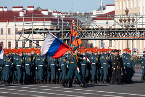 Russian military personnel with flags during a rehearsal for the May 9 Victory Parade on Palace Square pass against the background of the arch of the main headquarters.