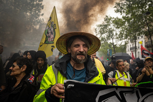 A protester is seen wearing a yellow vest during the labour day protest. A day full of clashes between the black-block, anarchists and anti-capitalists groups, with the police became the norm on the celebration of the 1st of May - Labour day in Paris, as demonstrators complaining about president Macron's government and his political and social law changes.