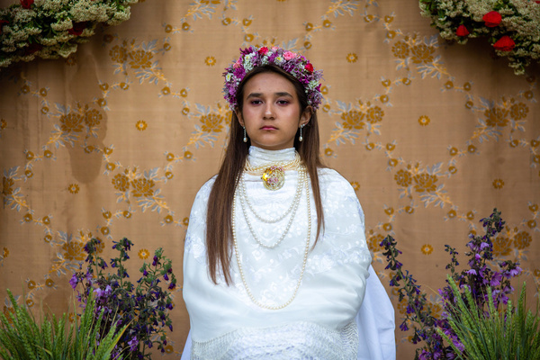 Julia, 13 years old, dressed as Maya, remains seated on an altar, during the celebration of "La Maya", in the Madrid town of Colmenar Viejo. "La Maya" refers to girls aged between 7 and 14 who sit for two hours at an altar adorned with flowers and plants to mark the arrival of spring. This tradition, originating from Colmenar Viejo, Madrid, traces back to medieval times, as per ancient records.