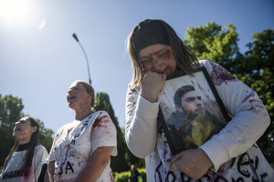 A Ukrainian woman covered with fake blood cries over a portrait of her family member, while Russian ambassador puts flowers at the monument at the cemetery to Red Army soldiers. On Russia's "Victory Day" in Warsaw Russia's Ambassador to Poland, Sergey Andreev and his delegation laid a wreath at the monument at the cemetery to Red Army soldiers who died during World War II. During the ceremony Ukrainian activists tried to disturb the event. May 9th, known as "Victory Day" in Russia, is a holiday commemorating the Soviet victory over Nazi Germany in 1945.