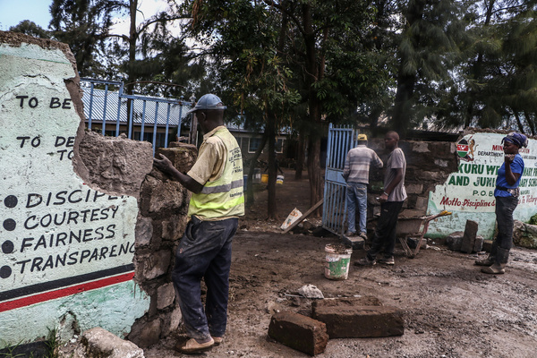Workers repair a wall that had been knocked down by floods at Nakuru West Primary and Junior Secondary in Nakuru. Some Kenyan schools have opened following a prolonged holiday due to the flooding situation experienced in many parts of the country.
