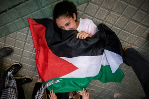 A protester holds a flag during the demonstration. Thousands of people participated in a demonstration through the streets of Pamplona calling for a free Palestine.