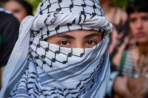 A child with his face covered with the keffiyeh scarf participates during the demonstration. Thousands of people participated in a demonstration through the streets of Pamplona calling for a free Palestine.