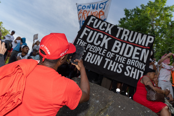 (EDITOR'S NOTE: Image depicts profanity) 
An attendee takes a photo of a placard saying "Fuck Trump, Fuck Biden, The People Of The Bronx, We Run This Shit" during a campaign event with former US President Donald Trump at Crotona Park in the Bronx.