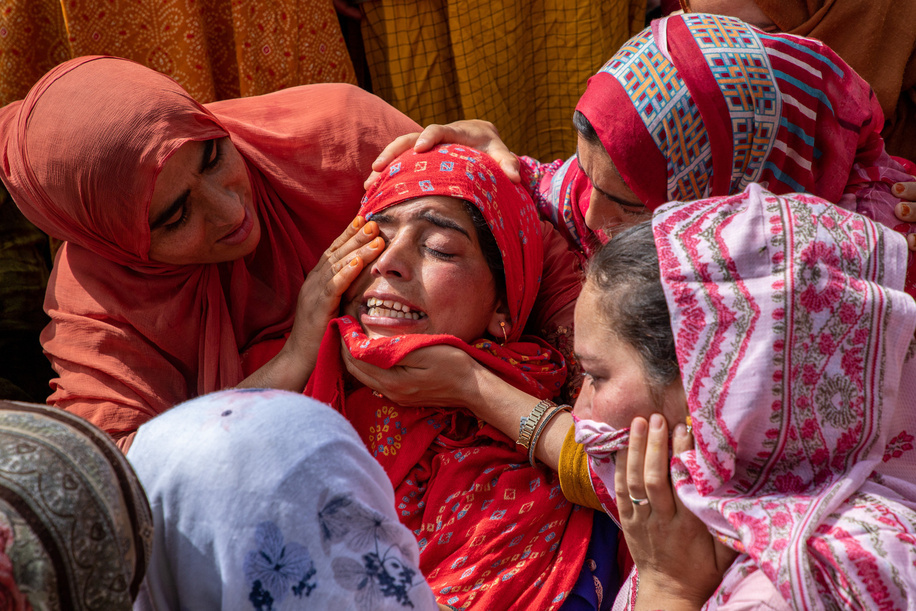 Neighbours console a woman near the dead body of slain former sarpanch or village head Aijaz Sheikh during his funeral procession after suspected militants fired upon him at his home last night in Heerpora Shopian, south of Srinagar. A former sarpanch or village head was slain and an Indian tourist couple injured in two separate militant strikes in Shopian and Anantnag last night, ahead of the Baramulla parliamentary constituency elections in Jammu and Kashmir.