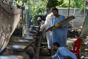 Traditional Kashmiri chefs prepare traditional Kashmiri wazwan in Srinagar. Wazwan (Kashmiri: وازِوان) is a traditional multi-course meal in Kashmiri cuisine, renowned as an art form and a cultural emblem. Predominantly meat-based, it features lamb and chicken, with a few vegetarian meals. It is prepared by master chefs called vaste waze, and the meal is typically served during weddings and reunions. Guests share the meal from a large copper platter (traem), they begin with rice and various meat types, including seekh kababs, methi korma, tabak maaz, safed kokur, and zafran kokur. Essential dishes include rista, rogan josh, daniwal korma, aab gosh, marchhwangan korma, and gushtaba, and they conclude with desserts. And its popularity has extended internationally to food festivals and cultural events.