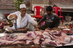 Traditional Kashmiri chefs cut lamb meat to prepare wazwan dishes in Srinagar. Wazwan (Kashmiri: وازِوان) is a traditional multi-course meal in Kashmiri cuisine, renowned as an art form and a cultural emblem. Predominantly meat-based, it features lamb and chicken, with a few vegetarian dishes. It is prepared by master chefs called vaste waze, and the meal is typically served during weddings and reunions. Guests share the meal from a large copper platter (traem), they begin with rice and various meat types, including seekh kababs, methi korma, tabak maaz, safed kokur, and zafran kokur. Essential dishes include rista, rogan josh, daniwal korma, aab gosh, marchhwangan korma, and gushtaba, and they conclude with desserts. And its popularity has extended internationally to food festivals and cultural events.