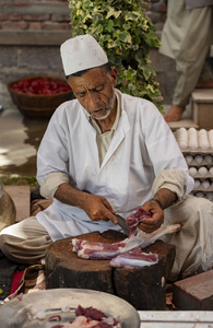 A Traditional Kashmiri chef cut lamb meat to prepare wazwan dishes in Srinagar. Wazwan (Kashmiri: وازِوان) is a traditional multi-course meal in Kashmiri cuisine, renowned as an art form and a cultural emblem. Predominantly meat-based, it features lamb and chicken, with a few vegetarian dishes. It is prepared by master chefs called vaste waze, and the meal is typically served during weddings and reunions. Guests share the meal from a large copper platter (traem), they begin with rice and various meat types, including seekh kababs, methi korma, tabak maaz, safed kokur, and zafran kokur. Essential dishes include rista, rogan josh, daniwal korma, aab gosh, marchhwangan korma, and gushtaba, and they conclude with desserts. And its popularity has extended internationally to food festivals and cultural events.