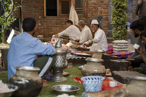 Traditional Kashmiri chefs cut lamb meat to prepare wazwan dishes in Srinagar. Wazwan (Kashmiri: وازِوان) is a traditional multi-course meal in Kashmiri cuisine, renowned as an art form and a cultural emblem. Predominantly meat-based, it features lamb and chicken, with a few vegetarian meals. It is prepared by master chefs called vaste waze, and the meal is typically served during weddings and reunions. Guests share the meal from a large copper platter (traem), they begin with rice and various meat types, including seekh kababs, methi korma, tabak maaz, safed kokur, and zafran kokur. Essential dishes include rista, rogan josh, daniwal korma, aab gosh, marchhwangan korma, and gushtaba, and they conclude with desserts. And its popularity has extended internationally to food festivals and cultural events.