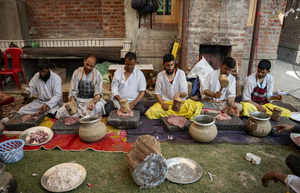 Traditional Kashmiri chefs smash lamb meat to prepare a dish called Gustaba in Srinagar. Wazwan (Kashmiri: وازِوان) is a traditional multi-course meal in Kashmiri cuisine, renowned as an art form and a cultural emblem. Predominantly meat-based, it features lamb and chicken, with a few vegetarian dishes. It is prepared by master chefs called vaste waze, and the meal is typically served during weddings and reunions. Guests share the meal from a large copper platter (traem), they begin with rice and various meat types, including seekh kababs, methi korma, tabak maaz, safed kokur, and zafran kokur. Essential dishes include rista, rogan josh, daniwal korma, aab gosh, marchhwangan korma, and gushtaba, and they conclude with desserts. And its popularity has extended internationally to food festivals and cultural events.