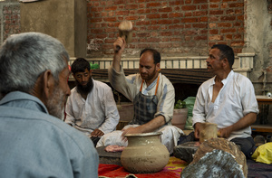 Traditional Kashmiri chefs smash lamb meat to prepare a dish called Gustaba in Srinagar. Wazwan (Kashmiri: وازِوان) is a traditional multi-course meal in Kashmiri cuisine, renowned as an art form and a cultural emblem. Predominantly meat-based, it features lamb and chicken, with a few vegetarian meals. It is prepared by master chefs called vaste waze, and the meal is typically served during weddings and reunions. Guests share the meal from a large copper platter (traem), they begin with rice and various meat types, including seekh kababs, methi korma, tabak maaz, safed kokur, and zafran kokur. Essential dishes include rista, rogan josh, daniwal korma, aab gosh, marchhwangan korma, and gushtaba, and they conclude with desserts. And its popularity has extended internationally to food festivals and cultural events.