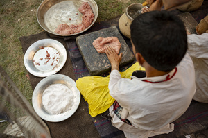 A traditional Kashmiri chef smashes lamb meat to prepare a dish called Gustaba in Srinagar. Wazwan (Kashmiri: وازِوان) is a traditional multi-course meal in Kashmiri cuisine, renowned as an art form and a cultural emblem. Predominantly meat-based, it features lamb and chicken, with a few vegetarian dishes. It is prepared by master chefs called vaste waze, and the meal is typically served during weddings and reunions. Guests share the meal from a large copper platter (traem), they begin with rice and various meat types, including seekh kababs, methi korma, tabak maaz, safed kokur, and zafran kokur. Essential dishes include rista, rogan josh, daniwal korma, aab gosh, marchhwangan korma, and gushtaba, and they conclude with desserts. And its popularity has extended internationally to food festivals and cultural events.