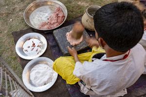 A traditional Kashmiri chef smashes lamb meat to prepare a dish called Gustaba in Srinagar. Wazwan (Kashmiri: وازِوان) is a traditional multi-course meal in Kashmiri cuisine, renowned as an art form and a cultural emblem. Predominantly meat-based, it features lamb and chicken, with a few vegetarian meals. It is prepared by master chefs called vaste waze, and the meal is typically served during weddings and reunions. Guests share the meal from a large copper platter (traem), they begin with rice and various meat types, including seekh kababs, methi korma, tabak maaz, safed kokur, and zafran kokur. Essential dishes include rista, rogan josh, daniwal korma, aab gosh, marchhwangan korma, and gushtaba, and they conclude with desserts. And its popularity has extended internationally to food festivals and cultural events.