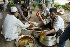 A traditional Kashmiri chef prepares a copper platter (trami) with wazwan dishes in Srinagar. Wazwan (Kashmiri: وازِوان) is a traditional multi-course meal in Kashmiri cuisine, renowned as an art form and a cultural emblem. Predominantly meat-based, it features lamb and chicken, with a few vegetarian dishes. It is prepared by master chefs called vaste waze, and the meal is typically served during weddings and reunions. Guests share the meal from a large copper platter (traem), they begin with rice and various meat types, including seekh kababs, methi korma, tabak maaz, safed kokur, and zafran kokur. Essential dishes include rista, rogan josh, daniwal korma, aab gosh, marchhwangan korma, and gushtaba, and they conclude with desserts. And its popularity has extended internationally to food festivals and cultural events.