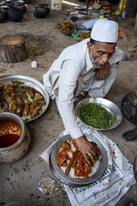 A traditional Kashmiri chef prepares a copper platter (trami) with wazwan dishes in Srinagar. Wazwan (Kashmiri: وازِوان) is a traditional multi-course meal in Kashmiri cuisine, renowned as an art form and a cultural emblem. Predominantly meat-based, it features lamb and chicken, with a few vegetarian dishes. It is prepared by master chefs called vaste waze, and the meal is typically served during weddings and reunions. Guests share the meal from a large copper platter (traem), they begin with rice and various meat types, including seekh kababs, methi korma, tabak maaz, safed kokur, and zafran kokur. Essential dishes include rista, rogan josh, daniwal korma, aab gosh, marchhwangan korma, and gushtaba, and they conclude with desserts. And its popularity has extended internationally to food festivals and cultural events.