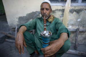 A traditional Kashmiri chef smokes as he prepares traditional wazwan dishes in Srinagar. Wazwan (Kashmiri: وازِوان) is a traditional multi-course meal in Kashmiri cuisine, renowned as an art form and a cultural emblem. Predominantly meat-based, it features lamb and chicken, with a few vegetarian meals. It is prepared by master chefs called vaste waze, and the meal is typically served during weddings and reunions. Guests share the meal from a large copper platter (traem), they begin with rice and various meat types, including seekh kababs, methi korma, tabak maaz, safed kokur, and zafran kokur. Essential dishes include rista, rogan josh, daniwal korma, aab gosh, marchhwangan korma, and gushtaba, and they conclude with desserts. And its popularity has extended internationally to food festivals and cultural events.