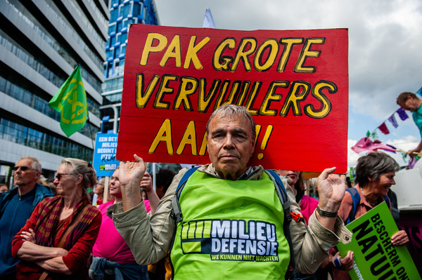 A man is seen holding a placard against the big polluters. Thousands of people gathered at the center of the financial heart of the Netherlands, in Amsterdam to stop billions in subsidies for fossil polluters. Several climate organizations want to demand a fair (climate) policy, just before the European elections.