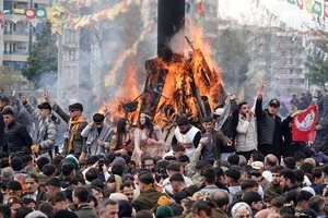 Young people are seen making victory signs in front of a fire lit during the Newruz celebration. Tens of thousands gather at the Newroz Square in Diyarbakir, the largest Kurdish-majority city during the final celebration of the Newroz holiday. The massive crowd celebrated with great enthusiasm, marking the occasion with vibrant festivities. This celebration is observed by the Kurdish people in Turkey across 89 locations this year.