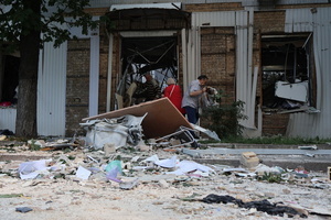 People clear debris from a building hit by a Russian drone amidst Russia's attack. Russia carried out "massive" drone attacks on Ukraine's capital and port city of Odesa killing one person and hitting a maternity hospital, Ukrainian officials said, and called for further sanctions.