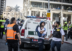 An Israeli medic carries a baby after an Iranian ballistic missile strike. An Iranian missile struck the main hospital in southern Israel early Thursday, causing extensive damage and wounding several people, though none seriously, according to the hospital. Other missiles hit a high-rise apartment building in Ramat Gan, and additional sites in central Israel, leaving at least 240 wounded and four of them seriously according to Israel's Health Ministry.