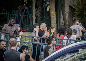 Israelis talk on their cellphones after an Iranian ballistic missile strike. An Iranian missile struck the main hospital in southern Israel early Thursday, causing extensive damage and wounding several people, though none seriously, according to the hospital. Other missiles hit a high-rise apartment building in Ramat Gan, and additional sites in central Israel, leaving at least 240 wounded and four of them seriously according to Israel's Health Ministry.