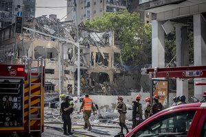 Israeli first responders seen at a site after an Iranian ballistic missile strike. An Iranian missile struck the main hospital in southern Israel early Thursday, causing extensive damage and wounding several people, though none seriously, according to the hospital. Other missiles hit a high-rise apartment building in Ramat Gan, and additional sites in central Israel, leaving at least 240 wounded and four of them seriously according to Israel's Health Ministry.