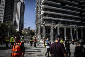 Israeli first responders seen near a building after an Iranian ballistic missile strike. An Iranian missile struck the main hospital in southern Israel early Thursday, causing extensive damage and wounding several people, though none seriously, according to the hospital. Other missiles hit a high-rise apartment building in Ramat Gan, and additional sites in central Israel, leaving at least 240 wounded and four of them seriously according to Israel's Health Ministry.