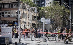 Israeli first responders seen near a building after an Iranian ballistic missile strike. An Iranian missile struck the main hospital in southern Israel early Thursday, causing extensive damage and wounding several people, though none seriously, according to the hospital. Other missiles hit a high-rise apartment building in Ramat Gan, and additional sites in central Israel, leaving at least 240 wounded and four of them seriously according to Israel's Health Ministry.