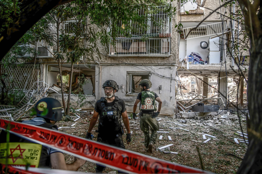 Paramedics search in a direct hit site of an Iranian ballistic missile in a residential neighbourhood.
