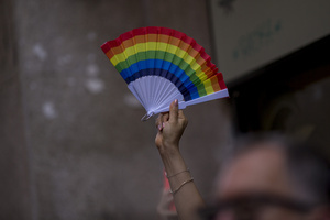 A member of the audience raises her fan in the colors of the LGBTQ+ flag during the High Heel Race on Pelayo Street. The 26th edition of the High Heel Race was held in the LGBTQ+ neighborhood of Chueca, a sporting and festive event that involves running in heels.