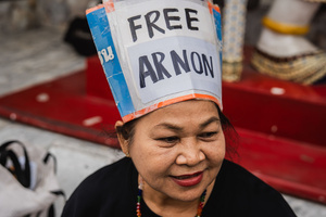 A woman wears a handmade hat reading “Free Arnon” during a vigil, calling for the release of detained human rights lawyer Arnon Nampa. People gathered outside Bangkok Art and Culture Centre for a candlelight vigil titled “Light Up Hope for the People’s Amnesty.” Organized ahead of a parliamentary debate on the 16 July 2025, the event featured personal testimonies, portraits of 50 political detainees, and a red rose display reading “Amnesty 112.” Participants called for the passage of a comprehensive amnesty bill covering cases under Section 112 of the Thai Criminal Code.