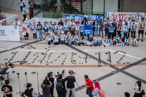 Protesters pose with portraits of activists during a vigil with red roses on the ground spelling out “Repeal 112,” referencing Section 112 of the Thai Criminal Code. People gathered outside Bangkok Art and Culture Centre for a candlelight vigil titled “Light Up Hope for the People’s Amnesty.” Organized ahead of a parliamentary debate on the 16 July 2025, the event featured personal testimonies, portraits of 50 political detainees, and a red rose display reading “Amnesty 112.” Participants called for the passage of a comprehensive amnesty bill covering cases under Section 112 of the Thai Criminal Code.